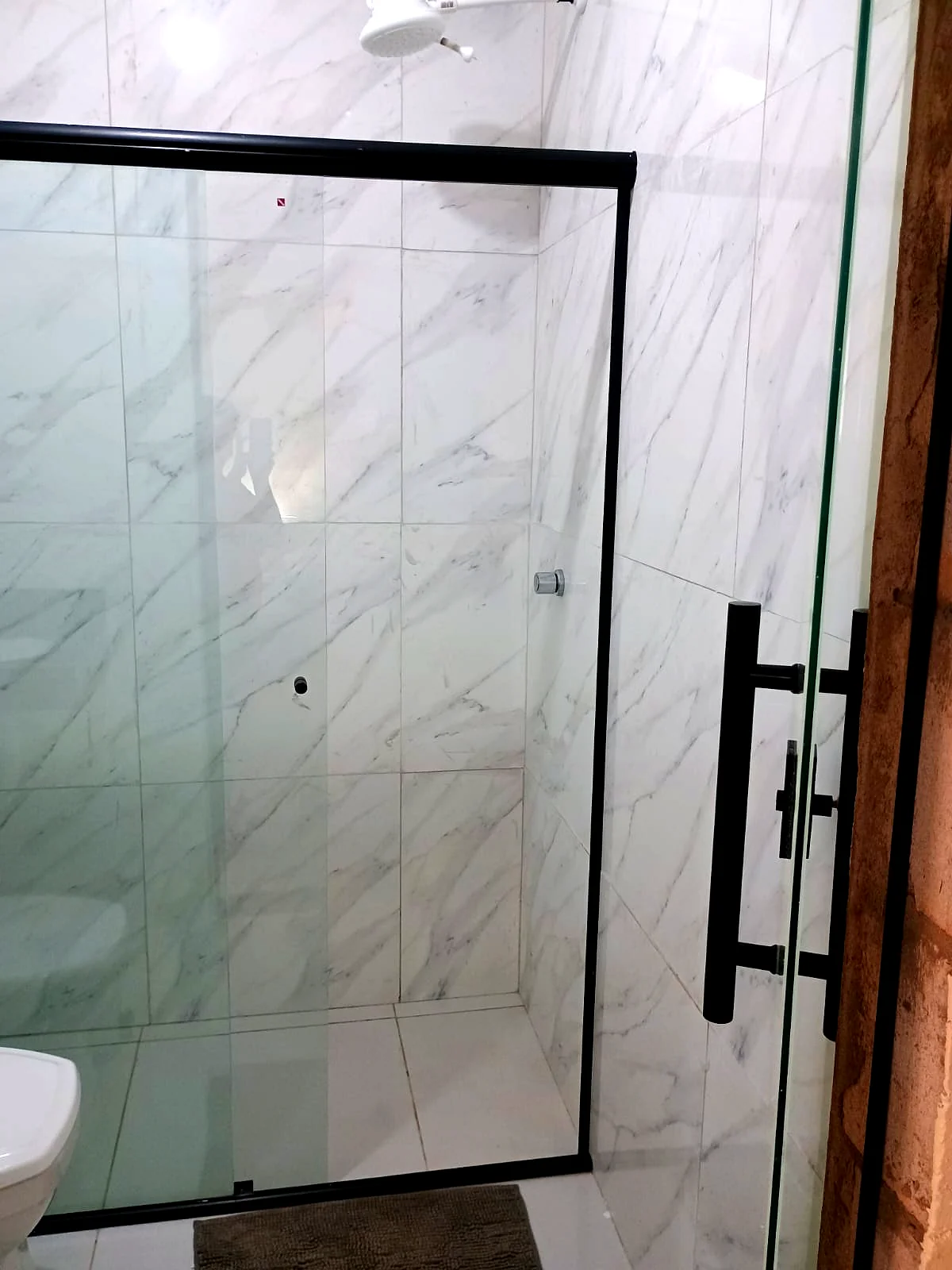 Banheiro privativo com box de vidro e perfil preto — Pousada Vale do Jamacá